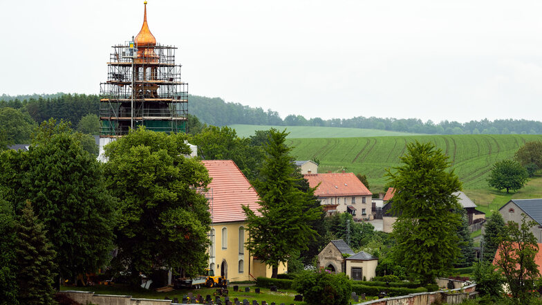 Der obere Teil des Goldbacher Kirchturmes wurde am Dienstag abgerüstet. Damit ist die restaurierte Turmkugel mit dem Kreuz und der Wetterfahne wieder weithin zu sehen – jetzt noch schöner als zuvor.