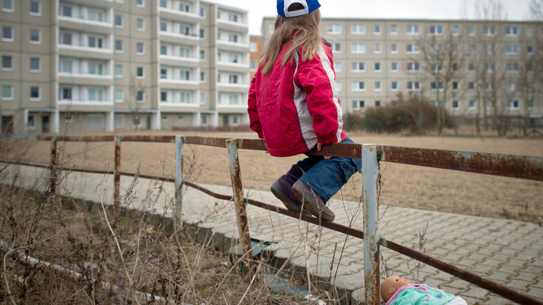 Ein kleines Mädchen sitzt allein auf einem rostigen Geländer. Immer wieder schrecken Fälle von vernachlässigten oder gar misshandelten Kindern auf.