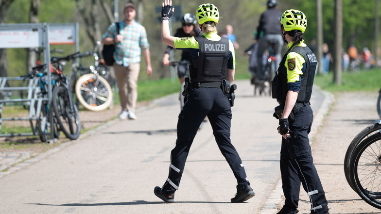 Polizeikommissarin Franz Winter hält einen Radfahrer auf dem Elberadweg an.