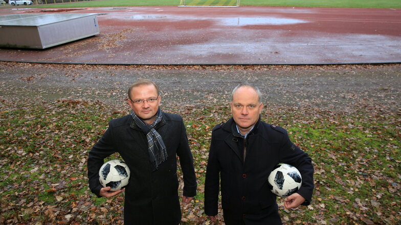 Auf der Sportanlage im Pulsnitzer Stadion stehen Pfützen. Sandro Karsch (l.) und Cornelius Hartmann von TSV Pulsnitz hoffen, dass im nächsten Jahr die Sanierung starten kann.