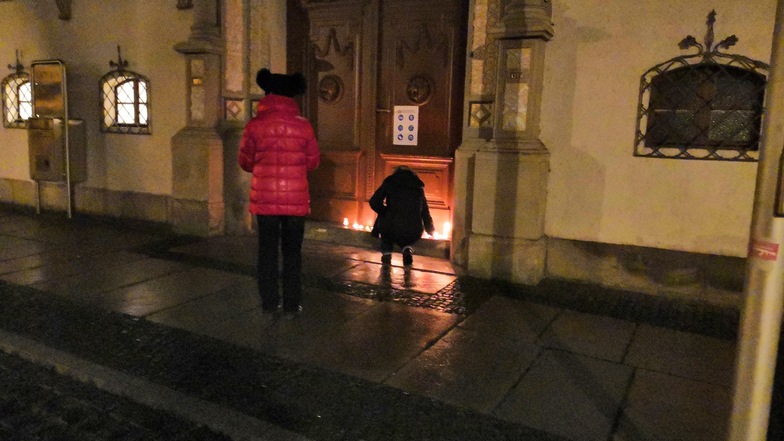 Manche stellten an der Rathaustür Kerzen ab - unter das Schild mit den Hygieneregeln.