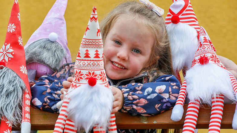 Die vierjährige Mia mit den selbst genähten Weihnachtswichteln. Mitstreiter vom Oderwitzer Kulturverein haben sie gefertigt. Sie werden Anfang Dezember an einem Stand verkauft.
