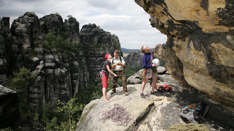 Kletterseilschaft und Nationalpark-Ranger. Das Felsklettern ist im sächsischen Naturschutzgesetz verankert.