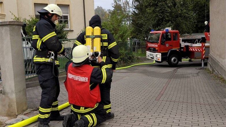 Die Feuerwehr Limmritz bereitet den nächsten Atemschutzträger für den Einsatz vor.