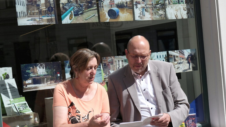 Petra Gürtler, Geschäftsführerin des SZ-Verlags DDV Elbland, und OB Olaf Raschke machen auf die Schaufensteraktion anlässlich der Jahrhundertflut in Meißen aufmerksam.
