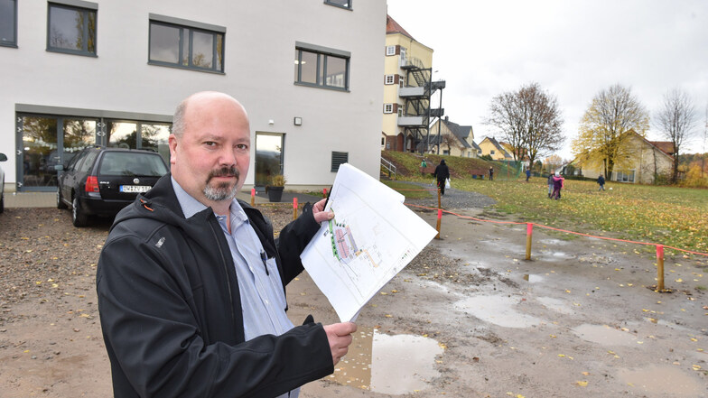 Falk Seidel, Bauamtsleiter der Stadt Rabenau, hält die Planung in Händen: Wie der neue Park- und Festplatz aussehen soll, steht bereits fest.
