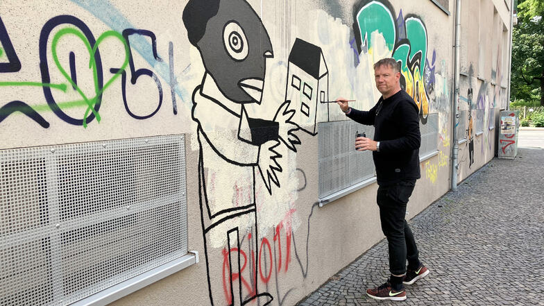 Der Künstler Michael Fischer-Art bemalt die Fassade eines Hauses im Stadtteil Connewitz. Nach eigenen Angaben wurde er am Vortag dabei von der Polizei überrascht.