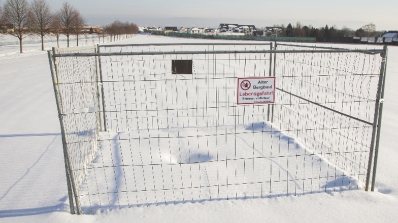 Schnee bedeckt derzeit den brüchigen Boden auf einem Feld in Bannewitz. Ein Bauzaun und ein Schild mahnen Spaziergänger derzeit zur Vorsicht.