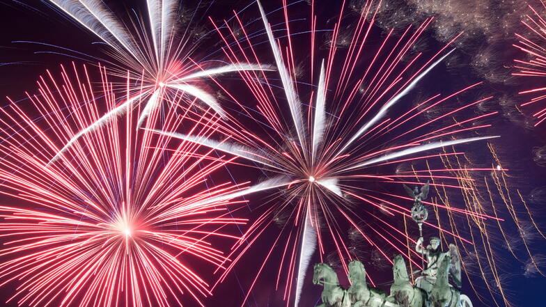 Ein Feuerwerk ist während der Silvesterparty hinter dem Brandenburger Tor zu sehen.