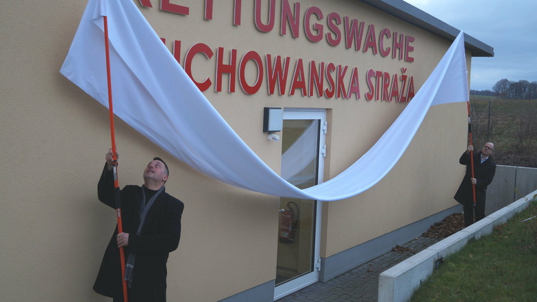 Gemeinsam mit Vize-Landrat Udo Witschas (l.) enthüllte der Domowina-Vorsitzende Dawid Statnik am Mittwoch den sorbischen Schriftzug an der Rettungswache in Bautzen-Stiebitz.