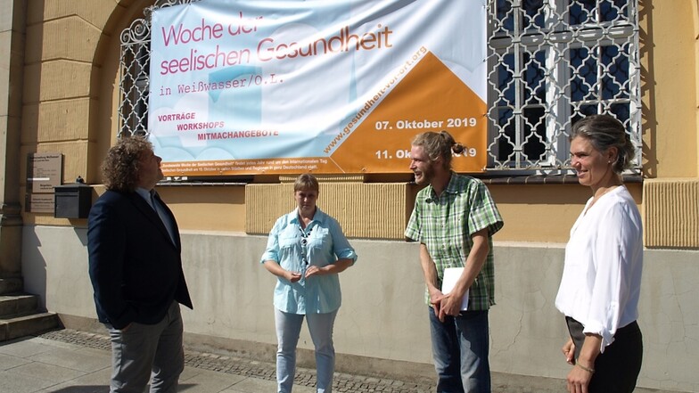 Romy Garner, Akteur Christian Hoffmann, Beate Altenkirch und OB Pötzsch (v.r.n.l.) vorm Transparent am Rathaus, das – wie weitere in der Stadt – für die Aktionswoche wirbt.