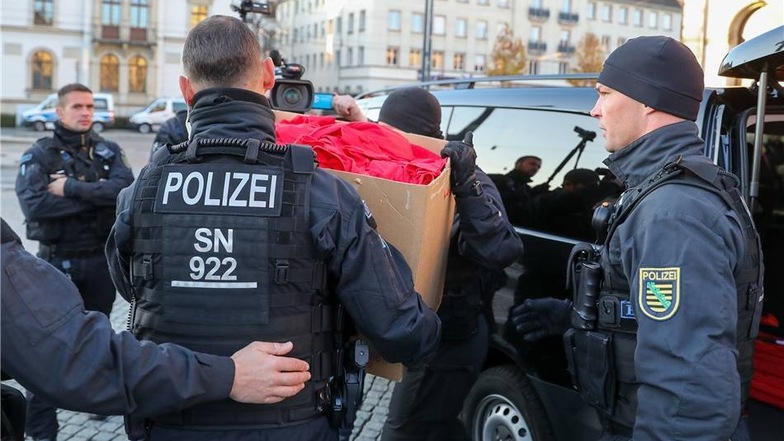 Die Polizei kassiert einen Karton voller "Merkeljugend"-T-Shirts ein.