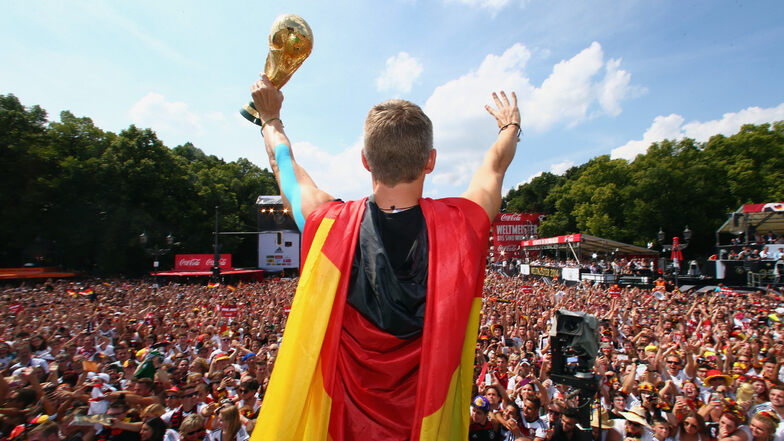 Bastian Schweinsteiger jubelt mit dem WM-Pokal auf der Fanmeile nach dem Sieg im Finale der Fußball-WM 2014 in Brasilien zwischen Deutschland und Argentinien.