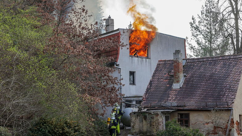 Flammen schlagen aus einem Haus in Meerane. Feuerwehrleute gingen unter Atemschutz und mit Wasser gegen die Flammen vor.