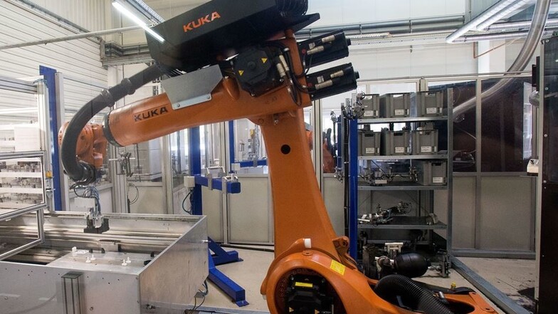 Investieren in die Zukunft: Kuka-Roboter helfen, Plastikteile mit toxischem Kleber zu versehen. Diese Teile werden dann im Leipziger BMW-Werk zügig in Elektroautos verbaut.