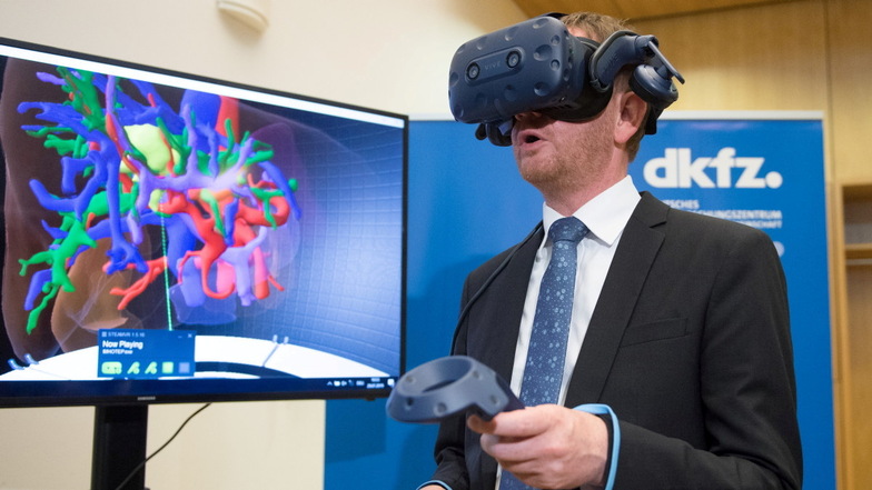 2019 betrachtet Michael Kretschmer mithilfe einer VR-Brille eine vom Krebs befallene Leber. Am selben Tag wurde die Vereinbarung zur Gründung einer Außenstelle des Deutschen Krebsforschungszentrums (DKFZ) in Dresden unterzeichnet.