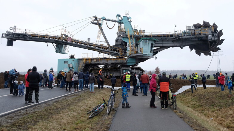 Schaulustige beobachten, wie ein 345 Tonnen schwerer Schaufelradbagger die Bundesstraße 176 zwischen Groitzsch und Neukieritzsch (Kreis Leipzig) überquert.