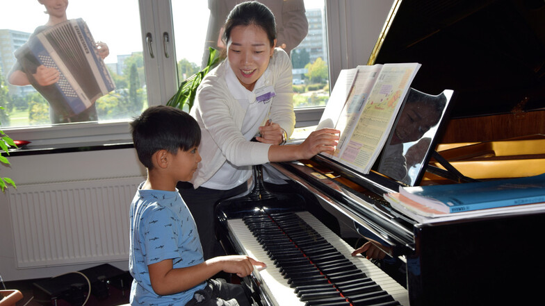 Die Klavierlehrerin Eunbin Oh arbeitet zum Tag der offenen Tür der Musikschule mit Arman am Flügel.
