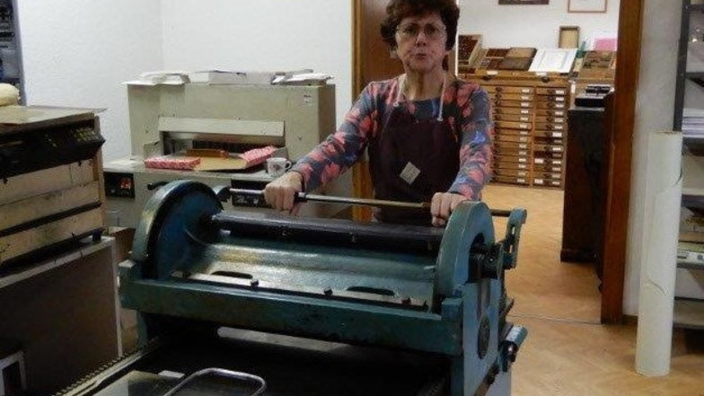 Petra Wasner mit der alten Abziehpresse am neuen Standort, der historischen Buchdruckerei Dohna.