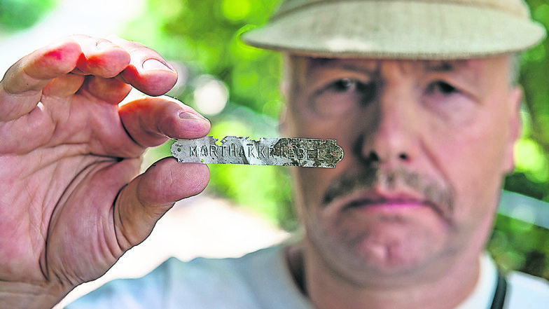 Pilzberater Steffen Hoeflich zeigt das Alu-Schildchen, in das der Name Martha Kriebel eingestanzt ist. Er hat es am Weinberg unterhalb der Heinzelstraße in einem Baumpilz gefunden.
