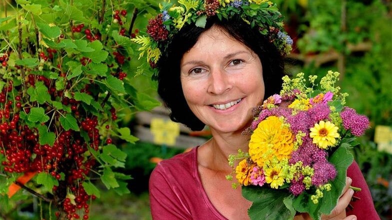 Petra Dietrich von der Baumschule Dietrich aus Nossen mit Blumenkrone und Blumenstrauß.