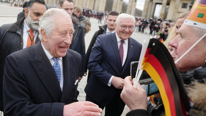 König Charles III. von Großbritannien (vorne l) begrüßt am Brandenburger Tor neben Bundespräsident Frank-Walter Steinmeier die Fans.