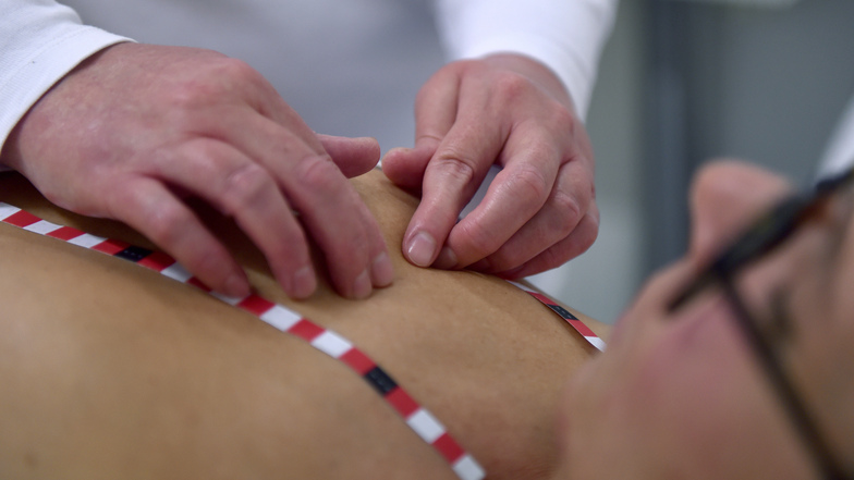Filiz Demir (l), blinde Medizinische Tastuntersucherin (MTU) bei Discovering Hands untersucht die Brust von einer Patientin. Die Klebestreifen dienen der Orientierung und der genauen Ortsbestimmung bei einem Befund.