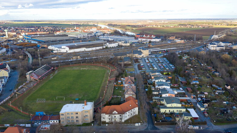Der Blick aus der Vogelperspektive zeigt das Ernst-Grube-Stadion in Riesa (l.) und die benachbarte Kolonie mit dem Pendlerparkplatz am Ende. Dahinter: der Bahnhof. Rechts, nicht mehr im Bild, verläuft die B 169 durch die Chemnitzer Hohle.