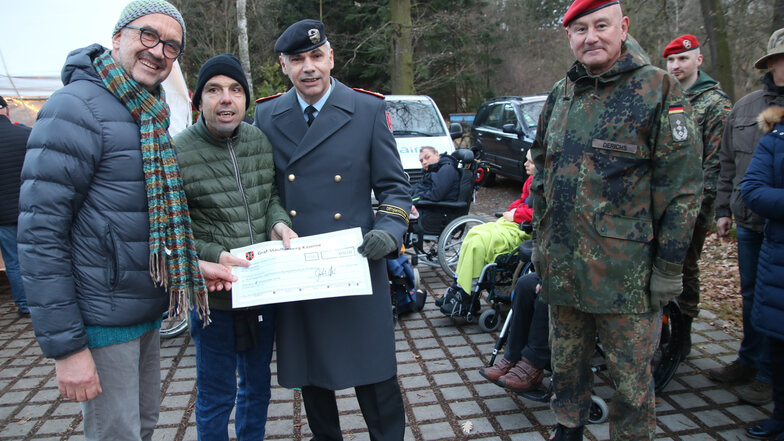 Einen Scheck über 600 Euro für die Liegauer Werkstätten hatten die Chefs der Offiziersschule Dresden mit zum Weihnachtsmarkt gebracht.