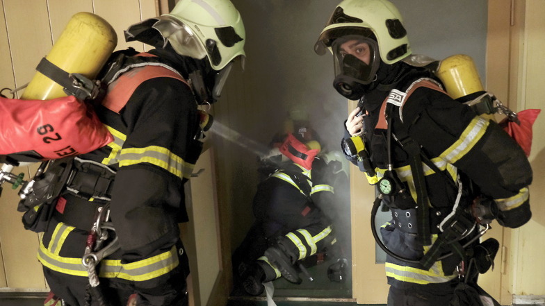Mit schwerem Atemschutz geht es zum Erstangriff in den völlig verrauchten Gebäudeteil.