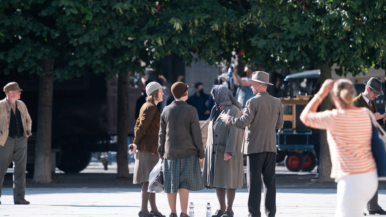 Komparsen warten auf ihren Einsatz bei den Dreharbeiten zum Seriendrama "Haus der Träume" auf dem Marienplatz in Görlitz.