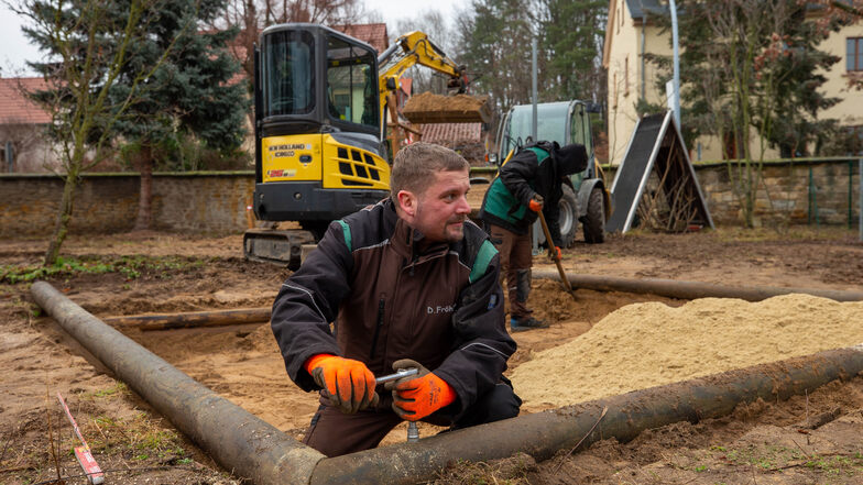 Daniel Fröhlich und seine Kollegen arbeiten am Spielplatz des Waldkindergarten Graupa. Hier wurden u.a. die Bäume um das Areal gestutzt und der Sandkasten neu aufgebaut.