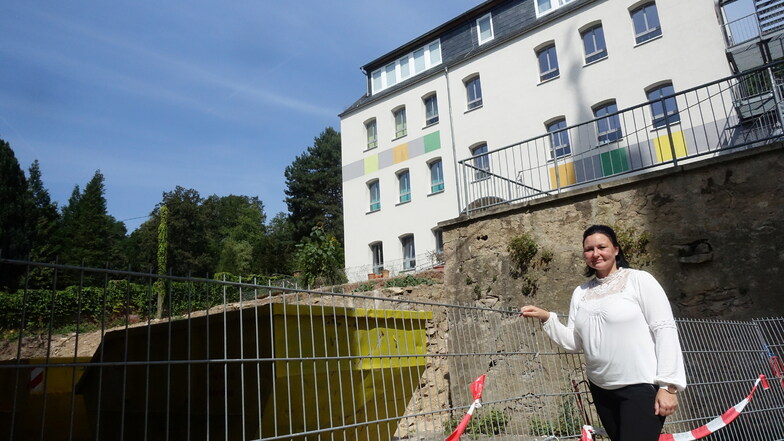 Geschäftsführerin Nelly Kührig auf der Rückseite der Grundschule. Hier gibt es erhebliche Höhenunterschiede. Der Anbau an die Schule soll auf der oberen Terrasse ausgeführt werden.