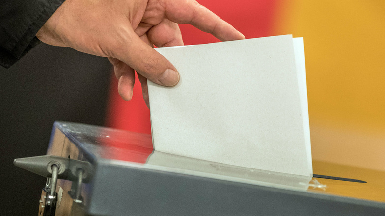in Wähler wirft seinen Stimmzettel zur Bundestagswahl in die Wahlurne. Das Wahlrecht soll reformiert werden.
