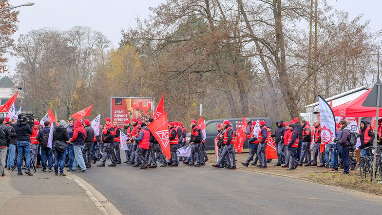Die Gewerkschafter überqueren die Straße, um vor dem Unternehmenstor zu streiken.