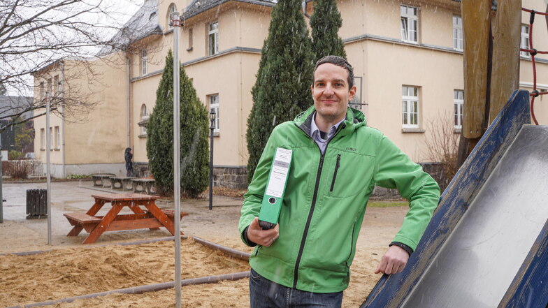 Bürgermeister Achim Wünsche steht auf dem Spielplatz der Grundschule in Putzkau. Hier soll perspektivisch der neue Hortanbau entstehen.
