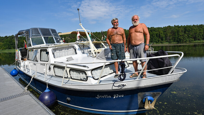 Peter Schneider (l) und Matthias Graupner, Freunde und Rentner, warten auf einem Boot auf der Spree vor der geschlossenen Kersdorfer Schleuse auf die Einfahrt zum Oder-Spree-Kanal.