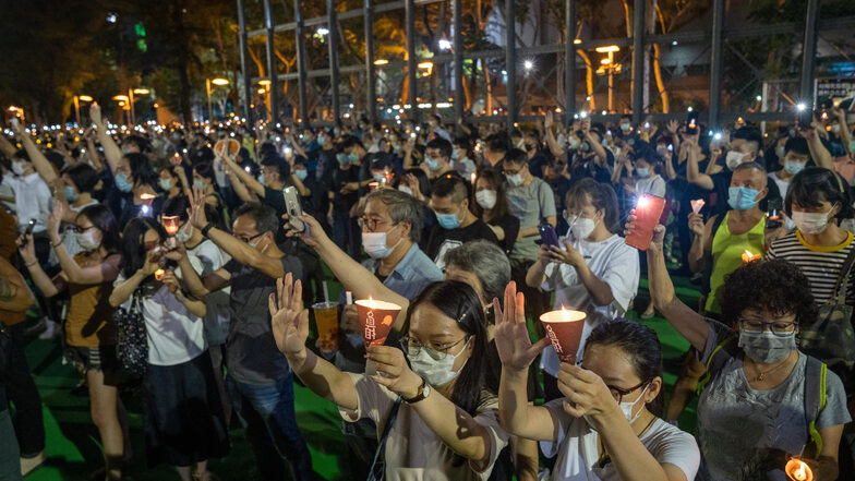 Trotz Corona-Beschränkung: Demonstranten versammeln sich im Victoria Park zu einer Mahnwache zum Gedenken an die Opfer des Tiananmen-Massakers. Die Menschen halten fünf Finger zum Zeichen von 5 Forderungen der pro-demokratischen Bewegung und eine Kerze mi