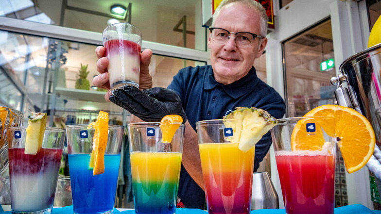 Vor dem Eingang des Kaufhauses Henwi ist eine Bar aufgebaut. Hannsjörg Schumann von der Agentur „Mitgedacht“ aus Weimar präsentiert farbenfrohe Cocktails.