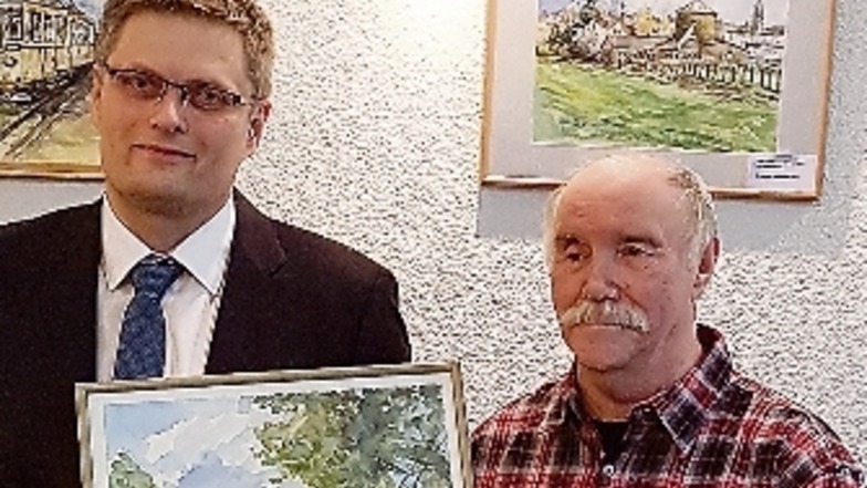 Der Weinböhlaer Hans Obenaus überreicht sein Bild, das den Schlosspark Schwetzingen zeigt, an Bürgermeister Siegfried Zenker.
