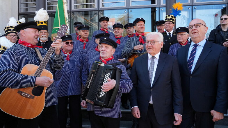 Bundespräsident Frank-Walter Steinmeier (2.v.r) und Dietmar Woidke (r, SPD), Ministerpräsident von Brandenburg, singen nach ihrer Ankunft auf dem Marktplatz mit dem Shanty-Chor und dem Chor der Bergarbeiter.