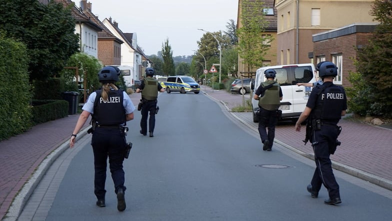 Polizisten gehen durch eine Straße der Kleinstadt Selm, wo zuvor ein Schüsse gefallen und ein Mensch verletzt worden war. Es kam zu einer Festnahme.