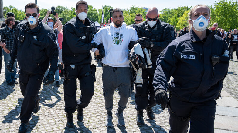 Attila Hildmann wird bei einer Demonstration vor dem Reichstagsgebäude von Polizisten abgeführt.