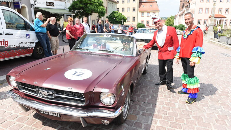 Mitglieder des Leisniger Carneval Clubs begrüßen Robert Athner und Toni Josteid, Teilnehmer der CC-Rallye Sachsen mit ihrem Ford in Leisnig und übergeben ein kleines Geschenk.
