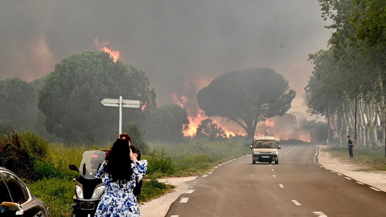 Eine Frau fotografiert in Saint-Andre in der Nähe von Argeles-sur-Mer im Südwesten Frankreichs einen Großbrand, der zur Evakuierung von rund 3.000 Touristen geführt hat.