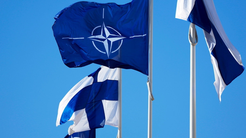 Die Nato-Flagge (M) und zwei finnische Flaggen flattern über dem Gebäude des finnischen Außenministeriums. Finnland ist offiziell in die Nato aufgenommen worden.