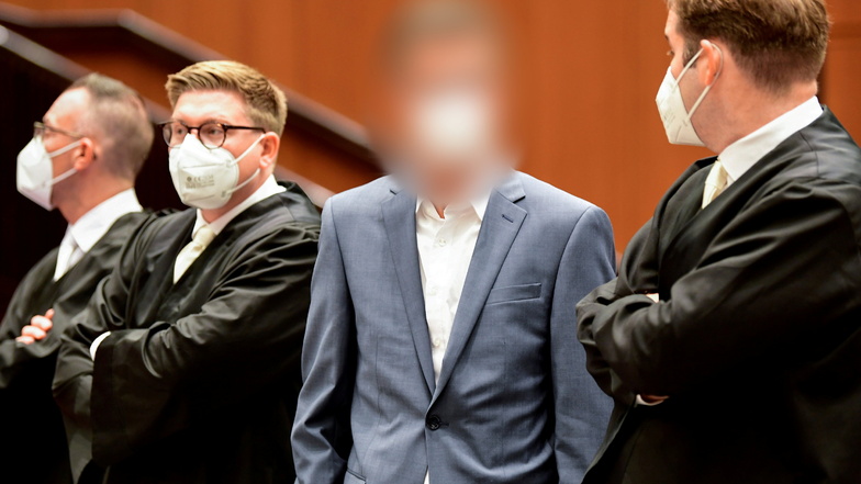 Einer der vier Angeklagten (2.v.r) steht zu Prozessbeginn in der Stadthalle Braunschweig.