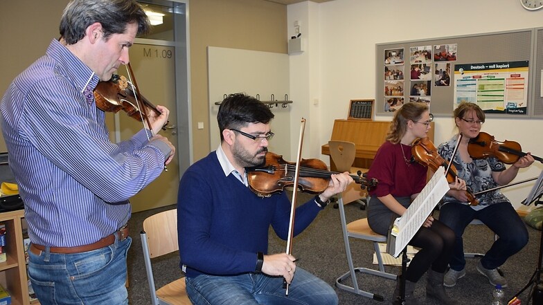 Der Musikpädagoge Christoph Geibel (links) probt mit den ersten Geigen. Erst als sich diese auf den gleichen Fingersatz an einer besonders komplizierten Stelle geeinigt hatten, konnten sie diese gut miteinander spielen.