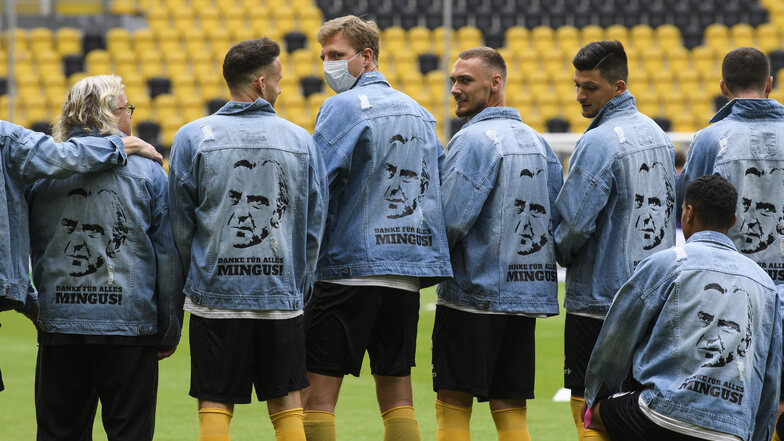 Die Mannschaft verabschiedet sich auf ihre Weise von Sportchef Minge, dessen Jeansjacke in Fußball-Dresden mittlerweile Kult-Charakter hat. Ein Duplikat mit Aufschrift tragen die Spieler bei der Erwärmung.