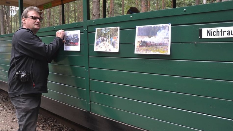 Olaf Urban befestigt während der Mittagspause einige Erinnerungsfotos der Letzten Fahrt auf der Tonbahn Mühlrose an einem der Wagen.